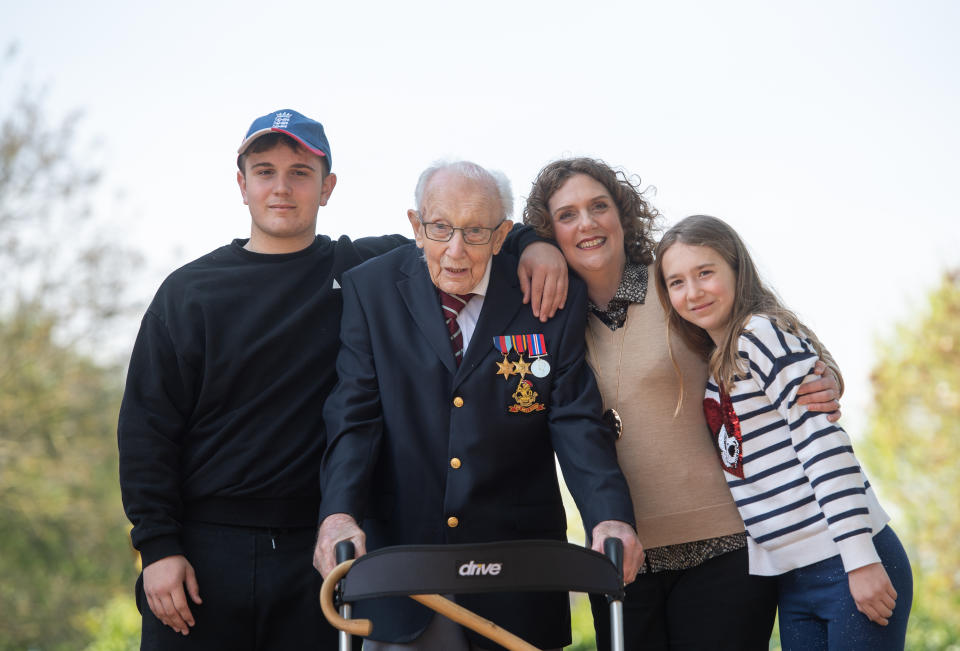 File photo dated 16/04/2020 of the then 99-year-old war veteran Captain Tom Moore, with (left to right) grandson Benji, daughter Hannah Ingram-Moore and granddaughter Georgia, at his home in Marston Moretaine, Bedfordshire, after he achieved his goal of 100 laps of his garden. Captain Sir Tom Moore has died at the age of 100 after testing positive for Covid-19, his daughters Hannah and Lucy said in a statement. Issue date: Tuesday February 2, 2021.