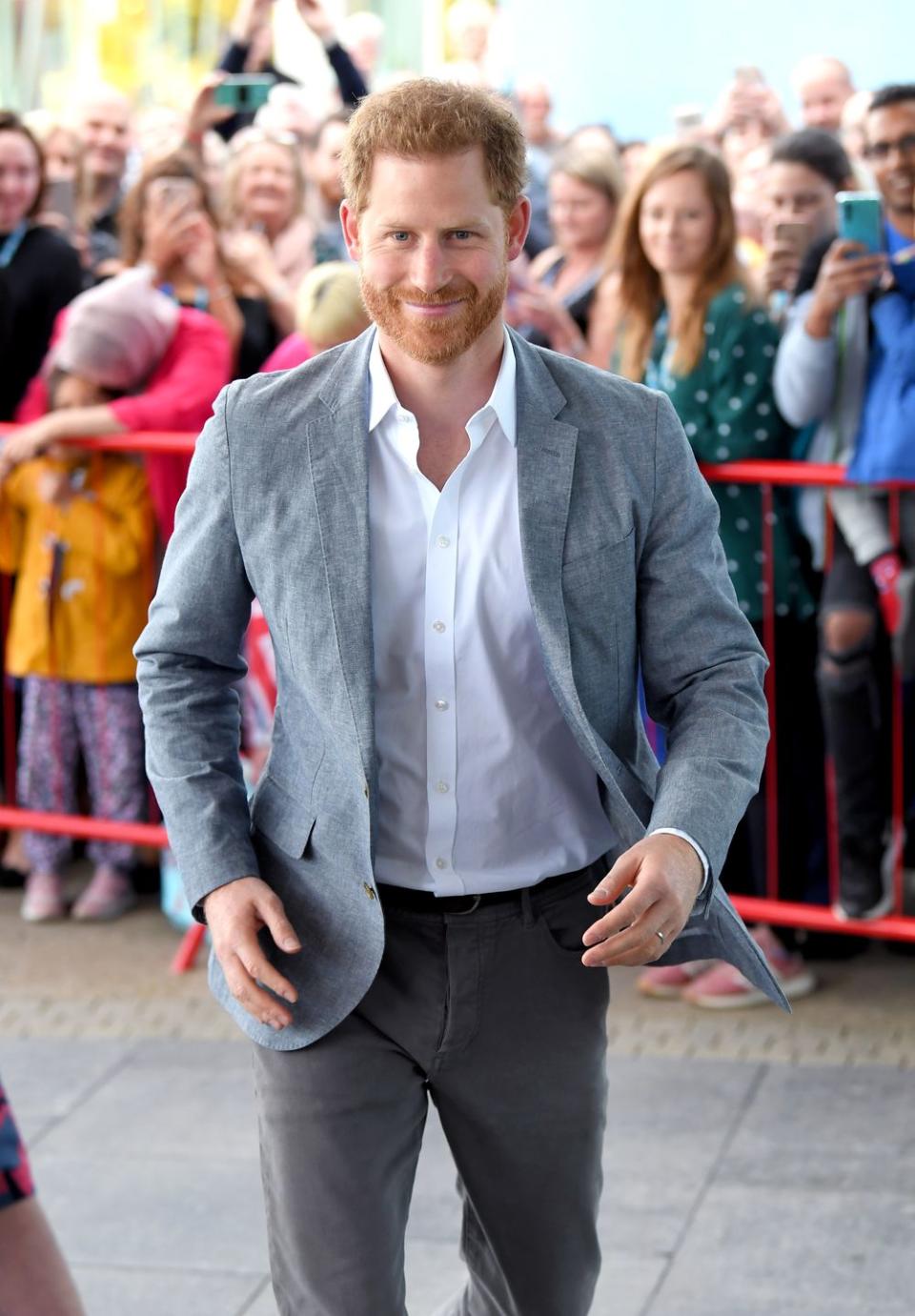 <p>Prince Harry smiles at crowds as he makes his way into John Ratcliffe Children's Hospital in Oxford, England. </p>