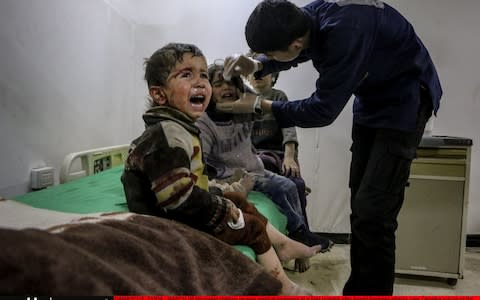 Wounded children receive medical treatment at a field hospital after an attack on the Zamalka neighbourhood - Credit: Getty