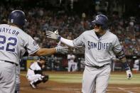San Diego Padres' Manny Machado, right, celebrates his home run against the Arizona Diamondbacks with teammate Josh Naylor (22) during the sixth inning of a baseball game Friday, Sept. 27, 2019, in Phoenix. (AP Photo/Ross D. Franklin)