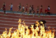 Competitors in the Men's 1500m Semifinal run past the Olympic torch on Day 9 of the London 2012 Olympic Games at the Olympic Stadium on August 5, 2012 in London, England. (Photo by Jeff J Mitchell/Getty Images)