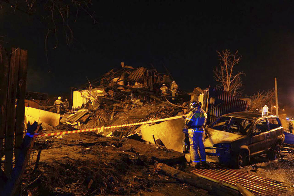 Firefighters work at the scene after a warplane crashed into a residential area in Irkutsk, Russia, Sunday, Oct. 23, 2022. A Russian warplane slammed into a residential building in the Siberian city of Irkutsk Sunday, killing both crewmembers — the second incident in less than a week in which a combat jet has crashed in a residential area. (AP Photo)