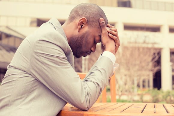 Man holding his head as if upset or stressed.