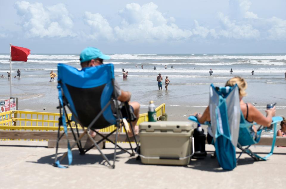 A couple sits along the Michael J. Ellis Beach seawall ahead of Hurricane Laura, Wednesday, Aug. 26, 2020, in Corpus Christi, Texas.