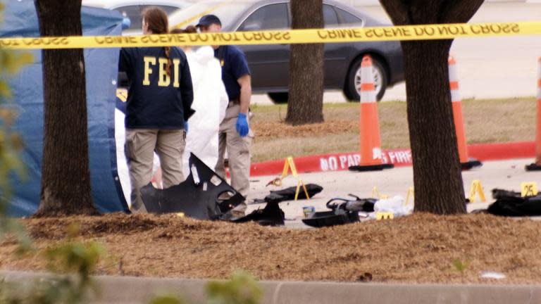 An FBI agent views the area where debris of a car was blown up by police as a precaution, near the Curtis Culwell Center on May 4, 2015 in Garland, Texas