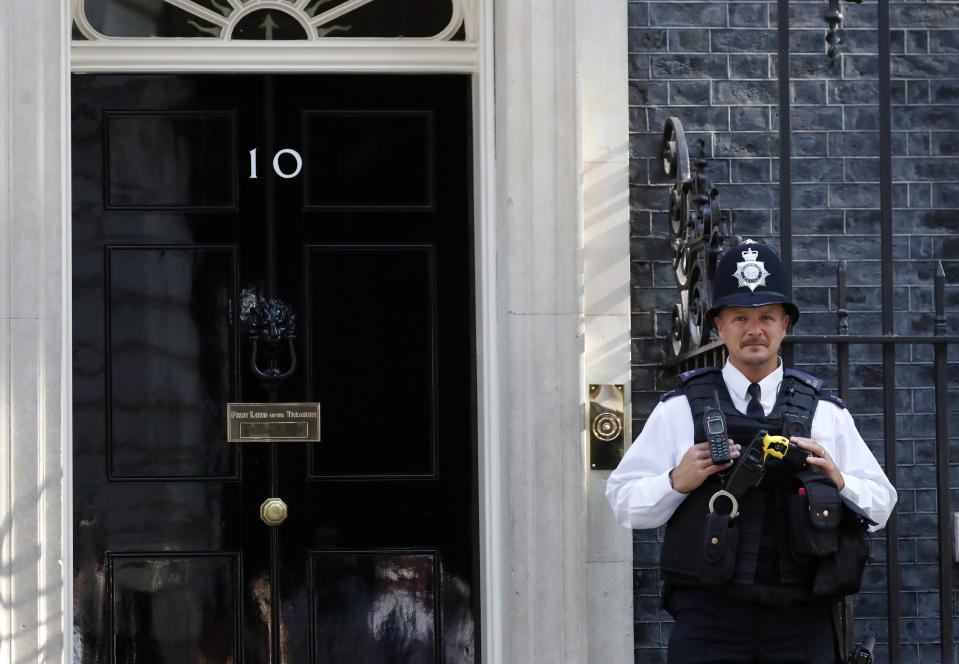 A police officer stands guard outside the Prime Minister's residence of 10 Downing Street in London, Wednesday, July 24, 2019. Boris Johnson will replace Theresa May as Britain's Prime Minister later Wednesday, following her resignation last month after Parliament repeatedly rejected the Brexit withdrawal agreement she struck with the European Union. (AP Photo/Frank Augstein)