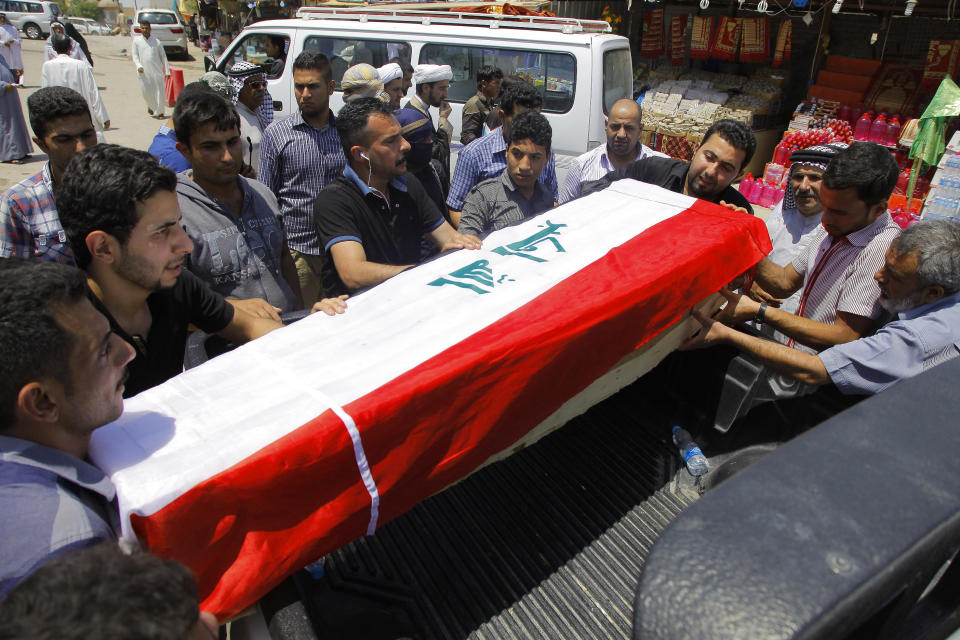 Family members of Majeed Abdullah, 31, who was killed in a bombing on Tuesday, load his flag-draped coffin onto a vehicle before his burial in the Shiite holy city of Najaf, 100 miles (160 kilometers) south of Baghdad, Iraq, Wednesday, May 14, 2014. Militants unleashed a wave of car bombings in Baghdad on Tuesday, killing dozens and sending thick, black smoke into the air in a show of force meant to intimidate Iraq’s majority Shiites as they marked what is meant to be a joyous holiday for their sect. (AP Photo/Jaber al-Helo)