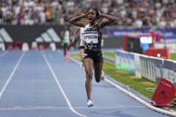 FILE - Faith Kipyegon, of Kenya, crosses the finish line to win the Women 5000 meters setting a new world record during the Meeting de Paris Diamond League athletics meet in Paris, Friday, June 9, 2023. (AP Photo/Michel Euler, File)