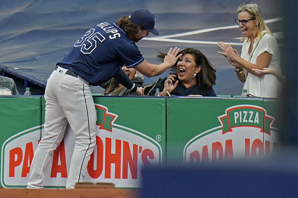 Tampa Bay Rays right fielder Brett Phillips laughs with a fan after Phillips made a catch on a foul out by Seattle Mariners' Dylan Moore during the fifth inning of a baseball game Wednesday, Aug. 4, 2021, in St. Petersburg, Fla. (AP Photo/Chris O'Meara)