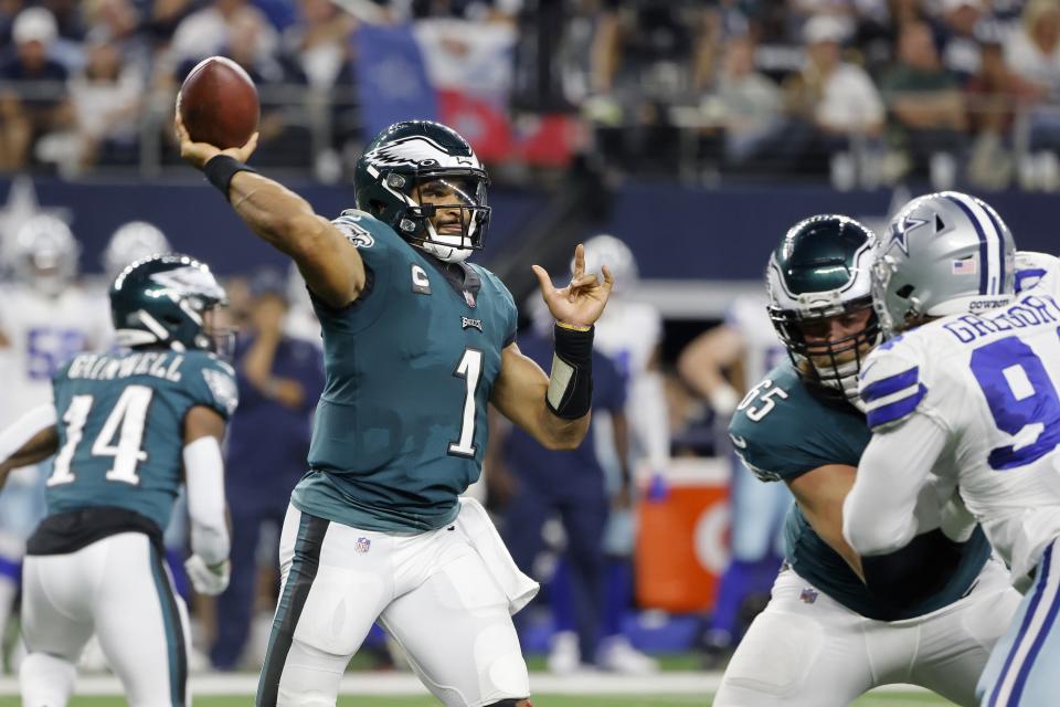 Philadelphia Eagles quarterback Jalen Hurts (1) throws a pass as offensive tackle Lane Johnson (65) defends against pressure from Dallas Cowboys defensive end Randy Gregory (94) in the second half of an NFL football game in Arlington, Texas, Monday, Sept. 27, 2021. (AP Photo/Michael Ainsworth)