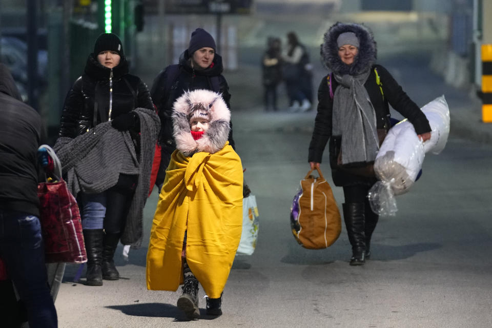 FILE - People fleeing the conflict in neighboring Ukraine cross the border in Przemysl, Poland, Feb. 27, 2022. Nearly six months after the Russian invasion of Ukraine, many refugees are still struggling to find jobs in their European Union host countries, despite the EU's streamlined process for Ukrainians to live and work in any of its 27 member nations. (AP Photo/Petr David Josek, File)