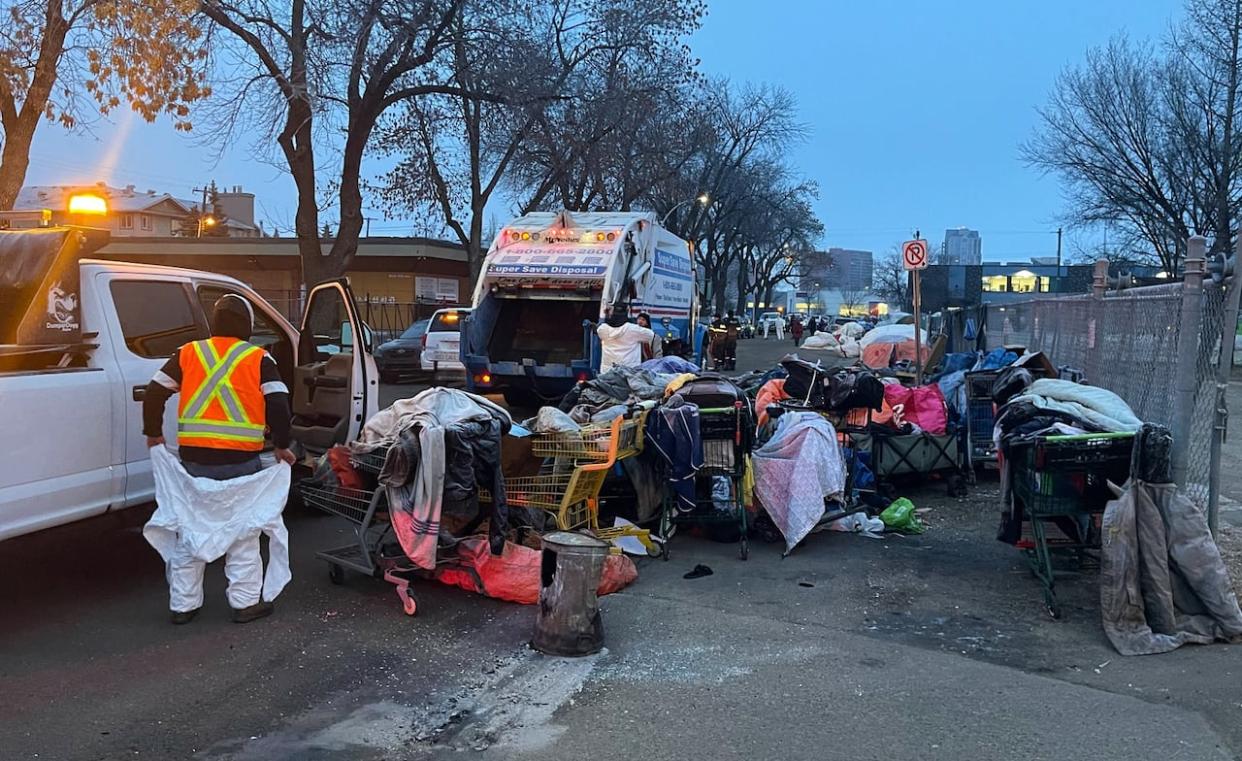 On Wednesday morning, city workers began dismantling an encampment near 105A Avenue and 96th Street in central Edmonton.  (Travis McEwan/CBC - image credit)