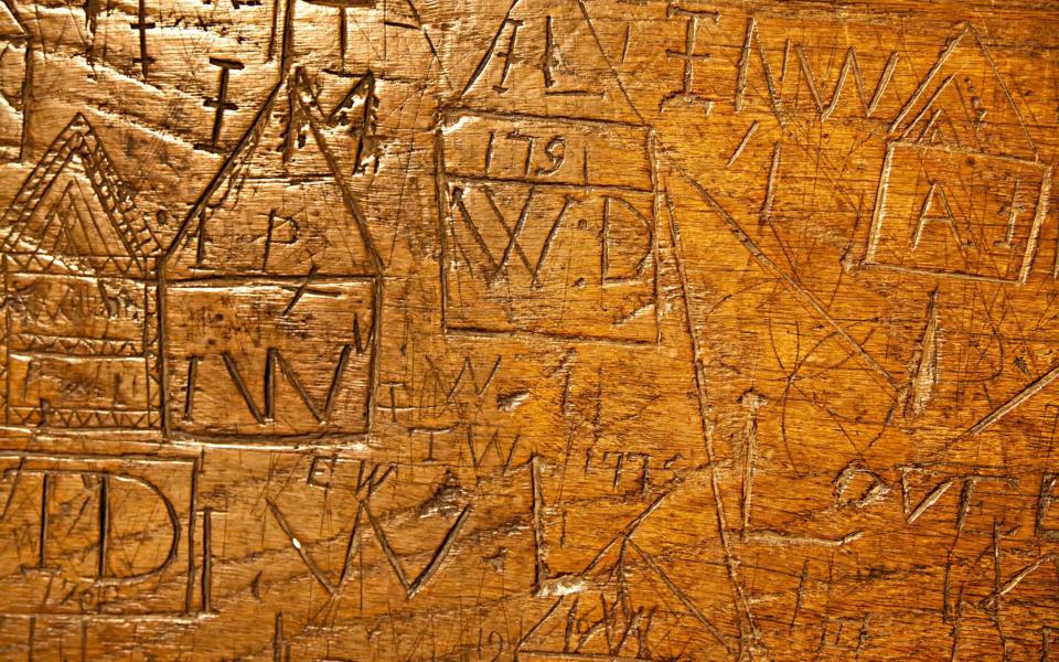 Graffiti carved into choir stalls in 18th century St Mary's Priory Church, Abergavenny, Wales