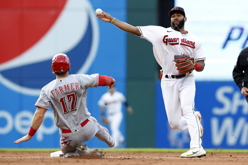 Cleveland Guardians' Amed Rosario throws to first after forcing out Cincinnati Reds' Kyle Farmer at second base, for the out on TJ Friedl at first base to complete a double play during the fifth inning of a baseball game, Tuesday, May 17, 2022, in Cleveland. (AP Photo/Ron Schwane)