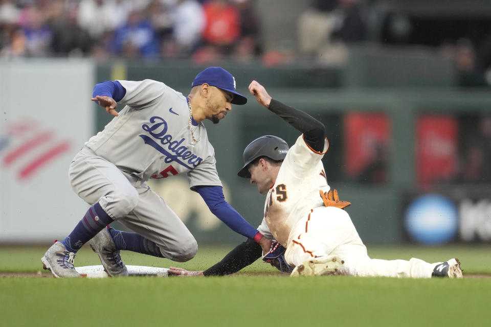 San Francisco Giants' Mike Yastrzemski, right, is tagged out by Los Angeles Dodgers second baseman Mookie Betts while trying to steal second base during the first inning of a baseball game in San Francisco, Monday, April 10, 2023. (AP Photo/Jeff Chiu)