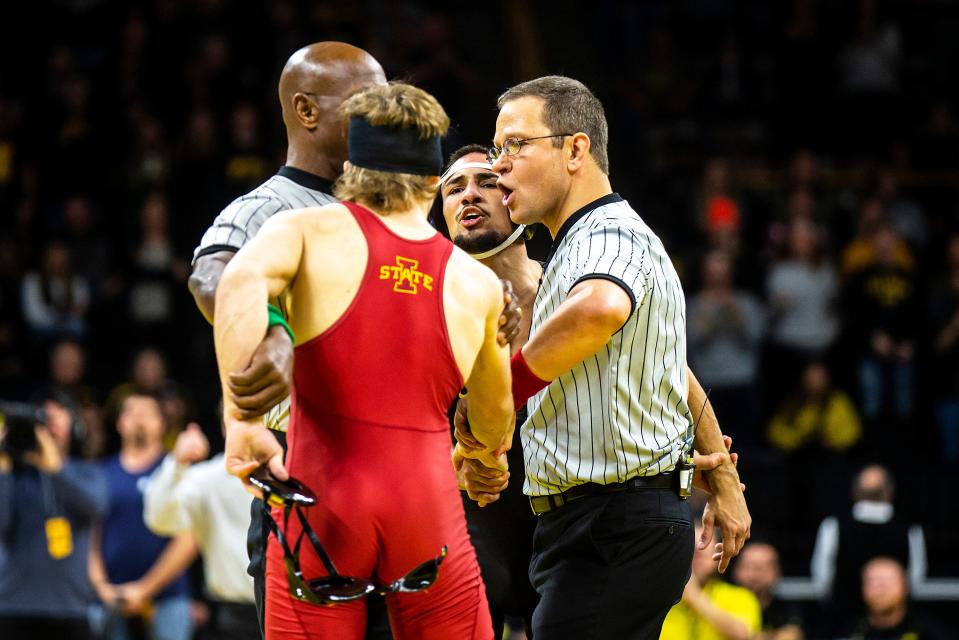 Iowa's Real Woods, second from right, and Iowa State's Casey Swiderski are separated by referees Titus Godbolt, left, and Matt Sorochinsky after Woods scored a decision at 141 pounds during a Cy-Hawk Series NCAA men's wrestling dual, Sunday, Dec. 4, 2022, at Carver-Hawkeye Arena in Iowa City, Iowa.