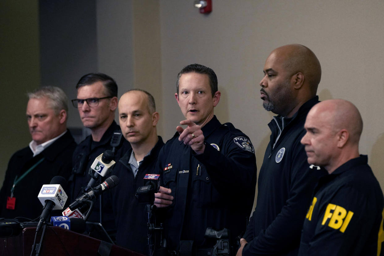 Michigan State University Interim Deputy Police Chief Chris Rozman, center, joins law enforcement officials while addressing the media, Tuesday, Feb. 14, 2023, in East Lansing, Mich. Police said a man suspected of killing several people and wounding others at the university on Monday night has died. Police said the man apparently shot himself off campus. (AP Photo/Carlos Osorio)