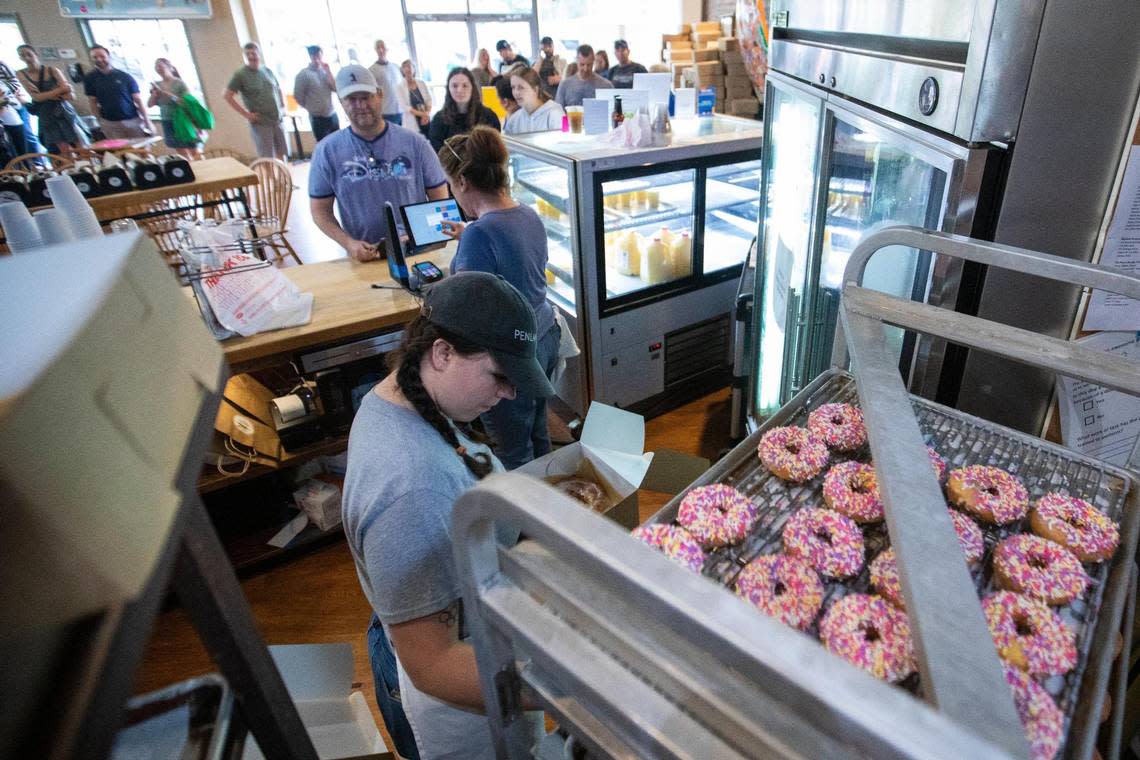 Employees box up baked goods for patrons who lined up around the corner of South Ashland and Main Street to try and purchase something on the last day of business for Magee’s Bakery in Lexington, Ky., Saturday, May 13, 2023. Some people waited in line over two hours. Silas Walker/swalker@herald-leader.com