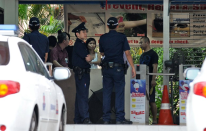 Policemen stand by the entrance to a foreign workers dormitory in Singapore on November 26, 2012. More than 100 mainland Chinese bus drivers in Singapore refused to work in a rare case of labour mass action in the city-state. AFP PHOTO/ROSLAN RAHMAN