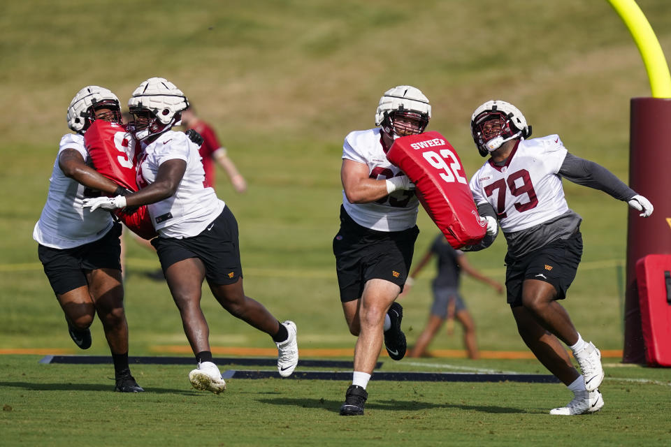 Washington Commanders guard Tyrese Robinson (79) works with others during practice at the team's NFL football training facility, Thursday, July 28, 2022 in Ashburn, Va. (AP Photo/Alex Brandon)