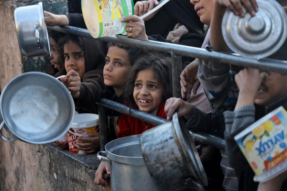 Displaced Palestinians collect food donated by a charity before an iftar meal, the breaking of the fast, on the first day of the Muslim holy fasting month of Ramadan in Rafah, on the southern Gaza Strip.