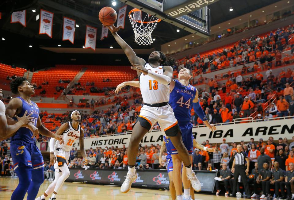 Oklahoma State guard Isaac Likekele (13) goes past Kansas forward Mitch Lightfoot (44) during the Jayhawks' 74-63 win Tuesday in Stillwater.