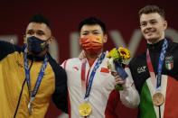 Gold medalist Chen Lijun of China, center, stands with silver medalist Javier Luis Masquera Lozano of Colombia, left, and bronze medalist Mirko Zanni of Italy, right, after the men's 67kg weightlifting event, at the 2020 Summer Olympics, Sunday, July 25, 2021, in Tokyo, Japan. (AP Photo/Luca Bruno)