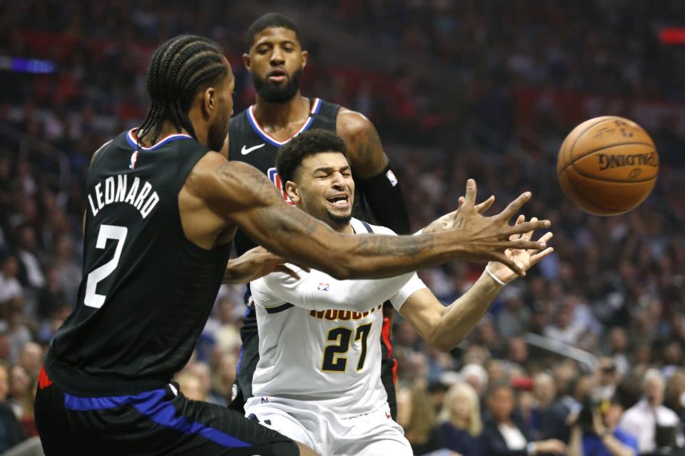 Clippers forwards Kawhi Leonard (2) and Paul George (13) trap Nuggets guard Jamal Murray.