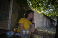 Olena Kanivets smokes a cigarette outside her home in Kupiansk-Vuzlovyi, Ukraine, Wednesday, Aug. 23, 2023. Despite intensified offensive operations by Russian forces in the area, Olena says she has nowhere to go and no money to start a new life. (AP Photo/Bram Janssen)