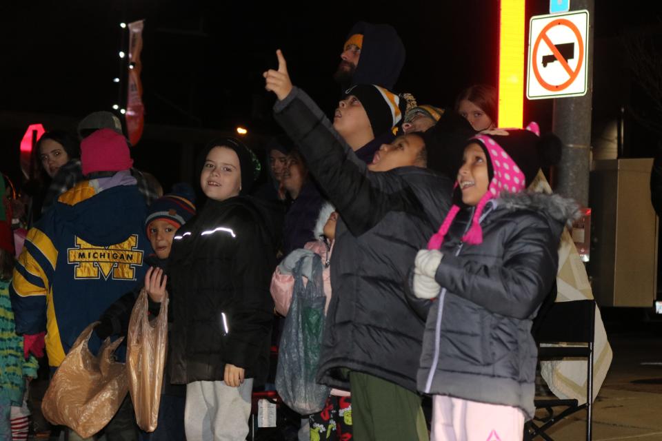 Children spot Santa Claus soaring through the sky amid the Fire & Ic”-themed seasonal holiday parade in downtown Fremont on Saturday.