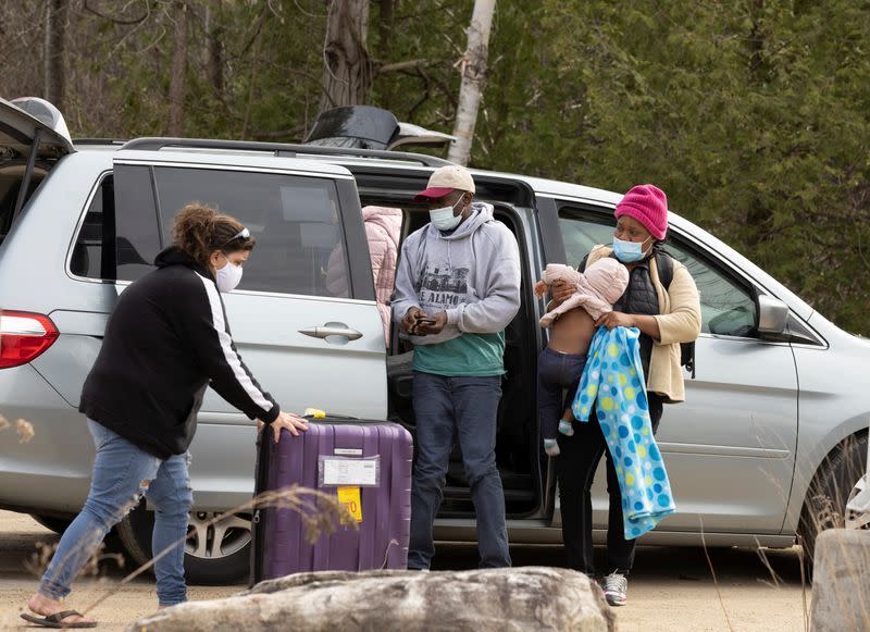 Asylum seekers cross into Canada near a checkpoint on Roxham Road