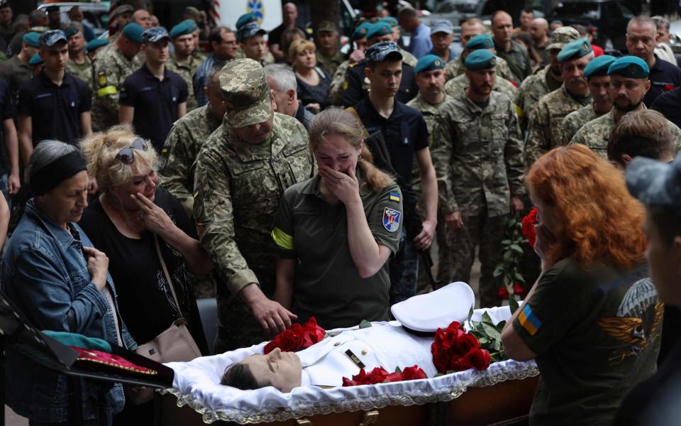 Relatives and comrades of Lieutenant Colonel Sergiy Derduga, Commander of the Ukrainian 18th Marine Battalion, mourn by his coffin during his funeral ceremony in Odesa, on June 6, 2022. Lieutenant Colonel Derduga was killed in the Mykolaiv region. - Oleksandr Gimanov/AFP