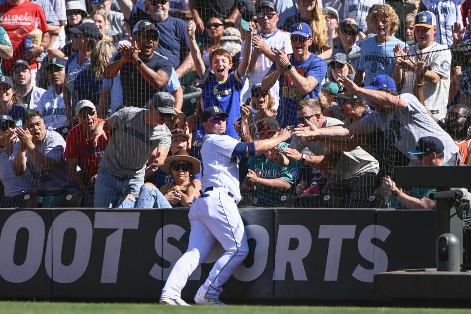 Seattle Mariners first baseman Ty France makes a catch at the netting of a foul ball hit by Los Angeles Angels' Kurt Suzuki during the ninth inning of a baseball game Saturday, Aug. 6, 2022, in Seattle. (AP Photo/Caean Couto)