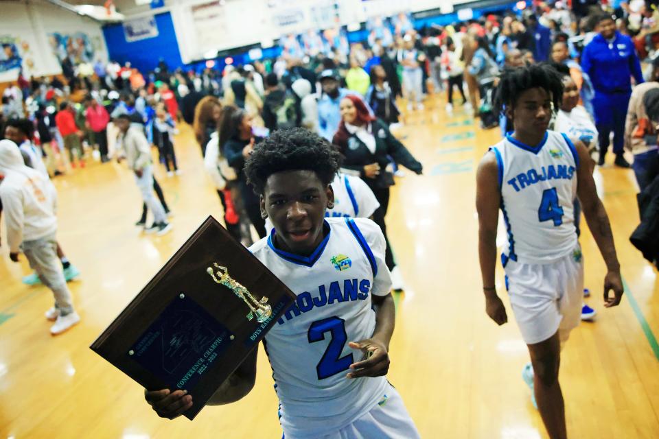 Ribault's George Woods (2) runs to the locker room with the team trophy after the game of the 2022-2023 Gateway Conference boys high school basketball tournament final Friday, Jan. 27, 2023 at Jean Ribault High School in Jacksonville, Fla. The Ribault Trojans defeated the Andrew Jackson Tigers 60-55 in overtime. [Corey Perrine/Florida Times-Union]