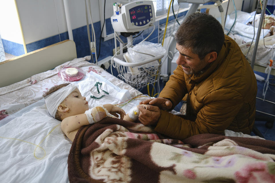 A man speaks with his child, wounded during shelling, in Stepanakert, the self-proclaimed Republic of Nagorno-Karabakh, Azerbaijan, Monday, Sept. 28, 2020. Fighting between Armenian and Azerbaijani forces over the disputed separatist region of Nagorno-Karabakh continued on Monday morning after erupting the day before, with both sides blaming each other for resuming the attacks. (Areg Balayan/PAN Photo via AP)