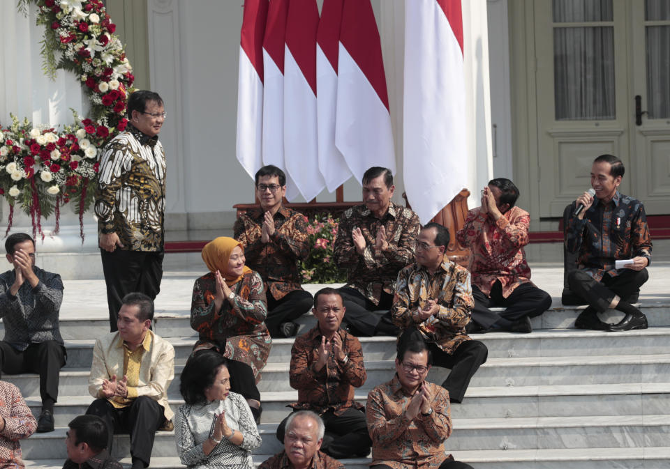 Newly appointed Defense Minister Prabowo Subianto, who is the former rival of Indonesian President Joko Widodo in last April's election, stands up as he is introduced by Widodo, right, during the announcement of the new cabinet at Merdeka Palace in Jakarta, Indonesia, Wednesday, Oct. 23, 2019. (AP Photo/Dita Alangkara)