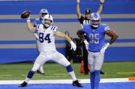 Indianapolis Colts tight end Jack Doyle (84) prepares to spike the ball next to Detroit Lions defensive end Romeo Okwara (95), after his 7-yard reception for a touchdown during the first half of an NFL football game against the Detroit Lions, Sunday, Nov. 1, 2020, in Detroit. (AP Photo/Tony Ding)