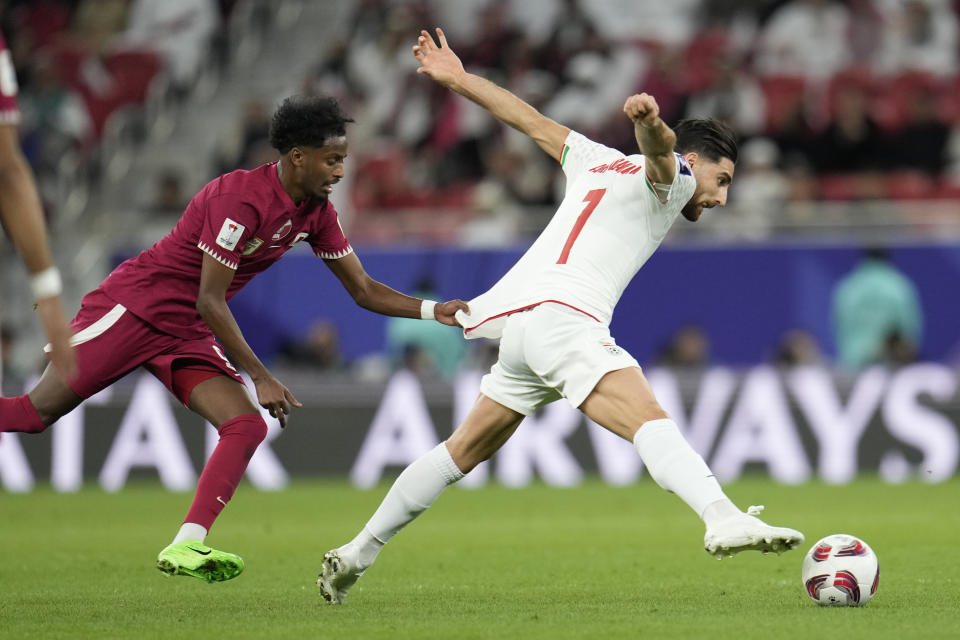 Iran's Alireza Jahan Bakhsh, right, is challenged by Qatar's Yusuf Abdurisag during the Asian Cup semifinal soccer match between Iran and Qatar at Al Thumama Stadium in Doha, Qatar, Wednesday, Feb. 7, 2024. (AP Photo/Aijaz Rahi)