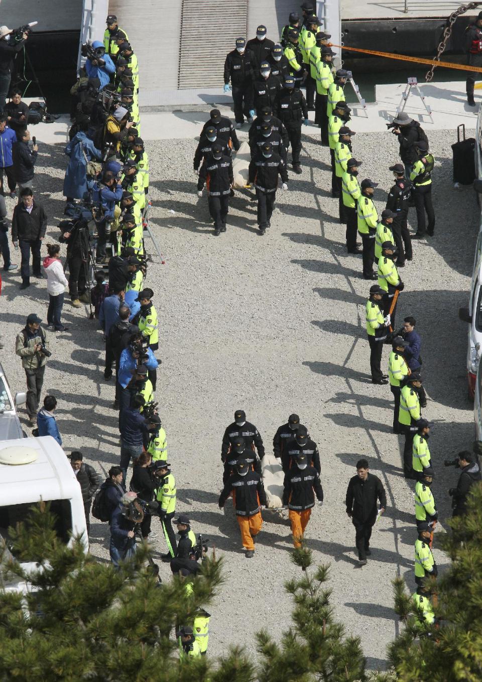 The bodies of passengers aboard the Sewol ferry which sank in the water off the southern coast, are carried by rescue workers upon their arrival at a port in Jindo, South Korea, Monday, April 21, 2014. Divers continued the grim work of recovering bodies from inside the sunken South Korean ferry Monday, as a newly released transcript showed the ship was crippled by confusion and indecision well after it began listing. The transcript suggests that the chaos may have added to a death toll that could eventually exceed 300. (AP Photo/Ahn Young-joon)