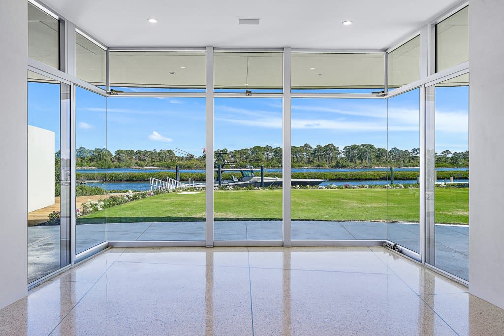 The property features floor-to-ceiling windows throughout. Waterfront Properties & Club C