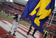 Michigan offensive lineman Trente Jones waves their flag to celebrate their win over Ohio State in an NCAA college football game on Saturday, Nov. 26, 2022, in Columbus, Ohio. (AP Photo/Jay LaPrete)