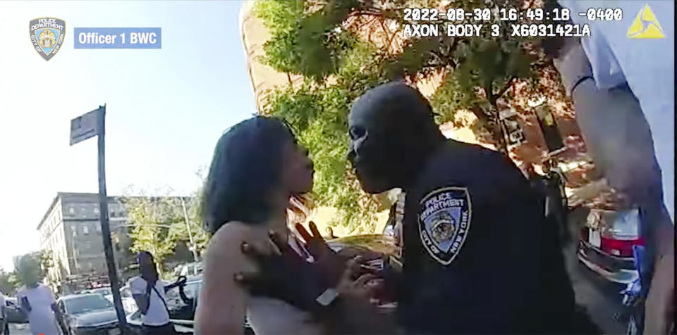 This still image from New York City Police Department body camera video, shows an incident Tuesday, Aug. 30. 2022, in which a detective shoved a woman to the ground after she struck him while he was helping officers arrest an attempted murder suspect in New York's Harlem neighborhood. The woman was one of three people involved in the incident who were arrested for interfering with police and charged with obstructing governmental administration, a misdemeanor. (New York City Police Department via AP)