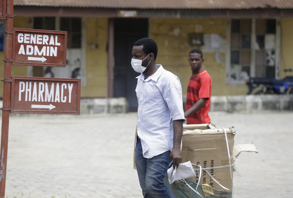 A man wearing face mask walks at the Yaba Mainland hospital where an Italian citizen who entered Nigeria on Tuesday from Milan on a business trip, the first case of the COVID-19 virus is being treated in Lagos Nigeria Friday, Feb. 28, 2020. Nigeria's health authorities have reported the country's first case of a new coronavirus in Lagos, the first confirmed appearance of the disease in sub-Saharan Africa. (AP Photo/ Sunday Alamba)