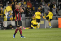 Atlanta United's Giorgos Giakoumakis covers his face as Columbus Crew players, right, celebrate a goal in the first half of an MLS playoff soccer match Wednesday, Nov. 1, 2023, in Columbus, Ohio. (AP Photo/Sue Ogrocki)
