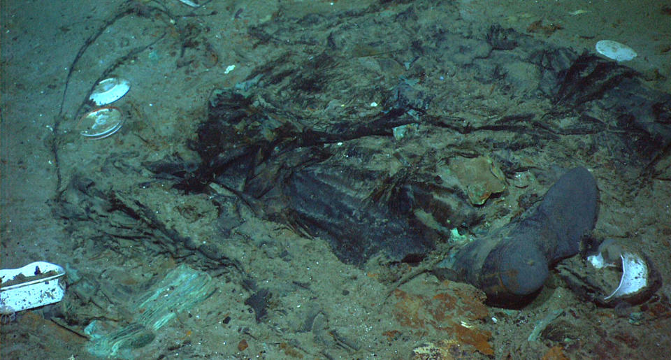 This 2004 photo provided by the Institute for Exploration, Center for Archaeological Oceanography/University of Rhode Island/NOAA Office of Ocean Exploration, shows the remains of a coat and boots in the mud on the sea bed near the Titanic's stern. Fallout from the coronavirus pandemic is threatening a company’s plans to retrieve and exhibit the radio that had broadcast distress calls from the sinking vessel, according to a court filing made by the firm on Monday, Jan. 11, 2021. (Institute for Exploration, Center for Archaeological Oceanography/University of Rhode Island/NOAA Office of Ocean Exploration)