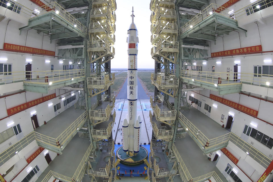 In this photo released by Xinhua News Agency, the Shenzhou-13 manned spaceship onto of a Long March-2F carrier rocket prepares to be transferred to the launching area of Jiuquan Satellite Launch Center in northwestern China, Oct. 7, 2021. China is preparing to send three astronauts to live on its space station for six months — a new milestone for a program that has advanced rapidly in recent years. (Wang Jiangbo/Xinhua via AP)