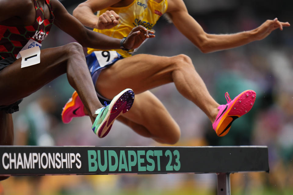 Vidar Johansson, of Sweden and Simon Kiprop Koech, of Kenya, clear a barrier in a heat of the Men's 3000-meters steeplechase during the World Athletics Championships in Budapest, Hungary, Saturday, Aug. 19, 2023. (AP Photo/Petr David Josek)