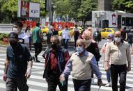 People wearing face masks to protect against the spread of coronavirus, walk in the city's historical part of Ulus, in Ankara, Turkey, Thursday, June 18, 2020. Turkish authorities have made the wearing of masks mandatory in three major cities to curb the spread of COVID-19 following an uptick in confirmed cases since the reopening of many businesses.(AP Photo/Burhan Ozbilici)