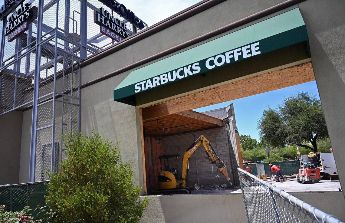 A construction worker is seen through the opening for a drive-thru at River Park’s Starbucks site in this file photo from June, 2022 in Fresno. The location will reopen with new features including the drive-thru.