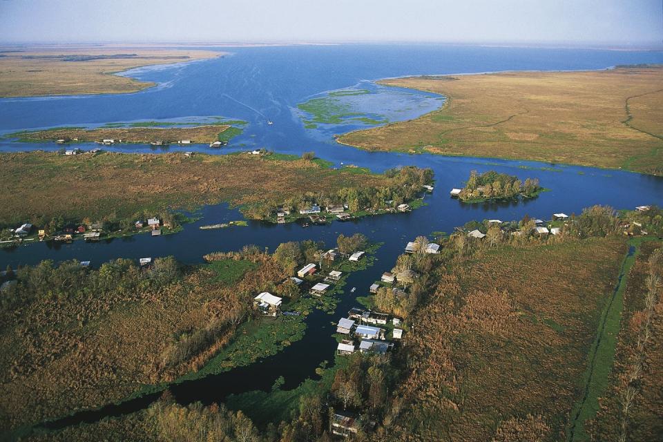 Aerial photo showing homes and covered docks lining the edges of a bayou.